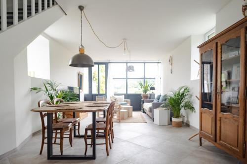 une salle à manger et un salon avec une table et des chaises dans l'établissement Gîte avec tennis en Baie du Mont Saint Michel à 15 minutes de la mer, à Les Chambres