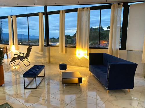 a living room with a blue couch and a large window at Heinz B. in Santa Ana de los Caballeros