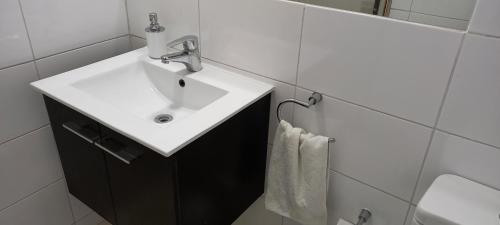 a bathroom with a white sink and a white towel at Casa Cómoda en La Cruz Quillota in La Cruz