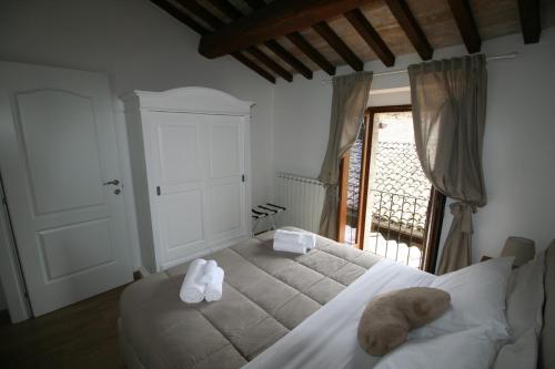 una camera da letto con un letto e due asciugamani di Residenza Porta Perlici Assisi Apartment ad Assisi