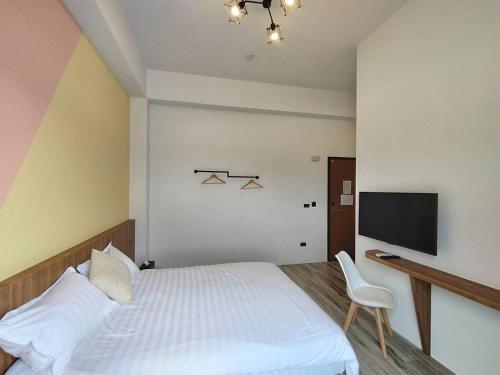 馬公市的住宿－甜心卡朵電梯私墅，卧室配有白色的床和电视。