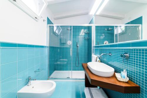 a blue tiled bathroom with a sink and a shower at Residenza Al Pesce D'Oro in Amalfi