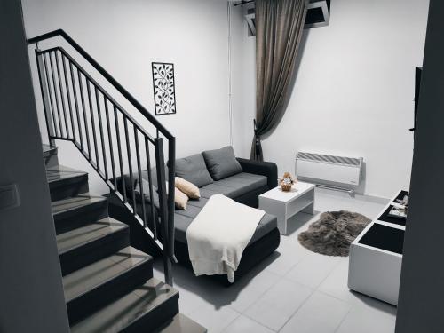 uma sala de estar com um sofá e uma escada em Apartman Katy em Sremska Mitrovica