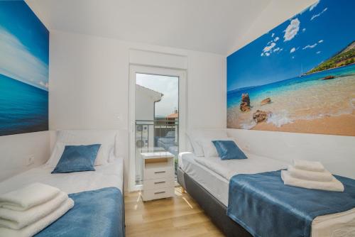 a bedroom with two beds and a painting on the wall at Apartment Marko in Malinska