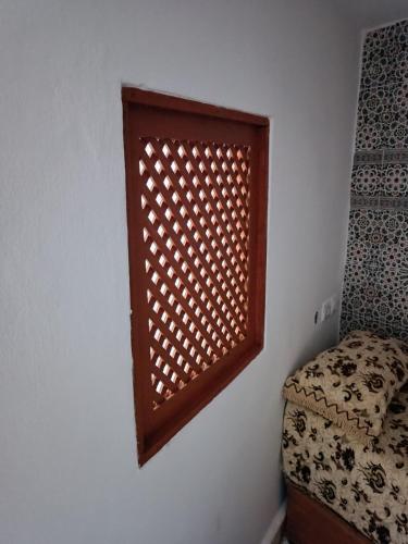 a window on a wall with a bed in a room at Appartement dans la médina in Asilah