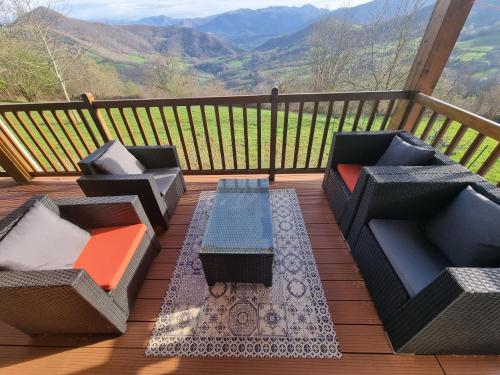 two chairs and a table on a deck with a view at Gîte Xuritenborda 7 personnes avec vue exceptionnelle sur les montagnes basque, Lits 180 King Size in Ossès