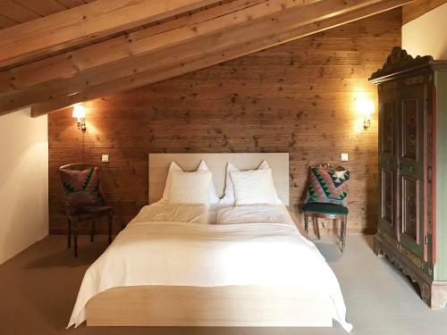 1 dormitorio con 1 cama blanca grande y 2 sillas en Haus Astrid, en Kitzbühel