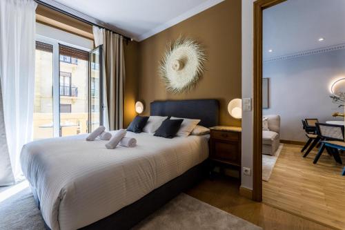 ONDARRA Suite Apartment في سان سيباستيان: غرفة نوم مع سرير وغرفة معيشة
