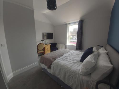 a bedroom with a bed and a window at Bay House in Totland