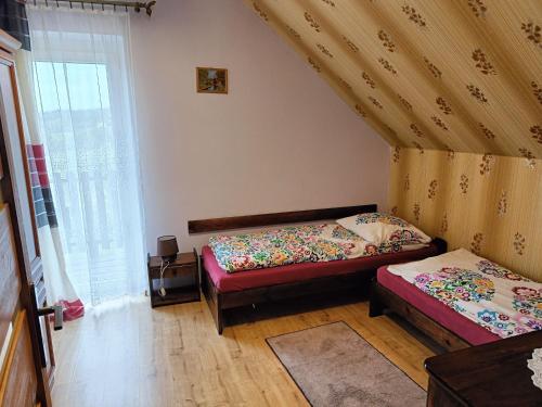 1 dormitorio con 2 camas y ventana en Dom na Zaciszu en Koniaków