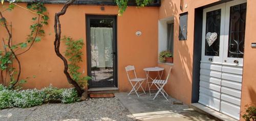 un patio con 2 sillas y una mesa frente a un edificio en Casa vacanze Tredis, en Nogaredo di Prato