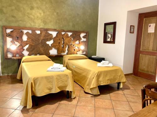 two beds in a room with yellow table cloth at Donnaciccina Accomodation in Tropea