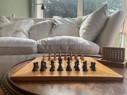 un tablero de ajedrez en una mesa frente a un sofá en Luxury large coastal retreat near the sea en Deal