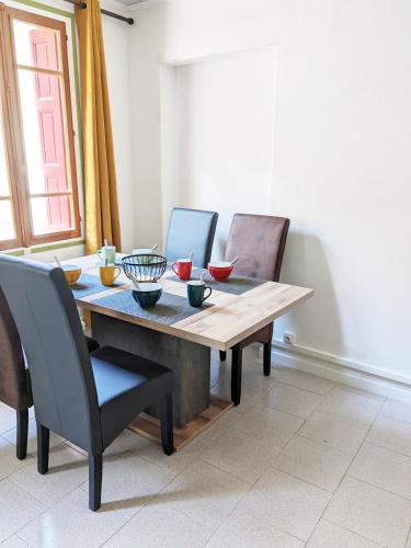 - une table à manger avec des bols dans l'établissement Appartement Le Fort Vue montagne, à Villefranche-de-Conflent