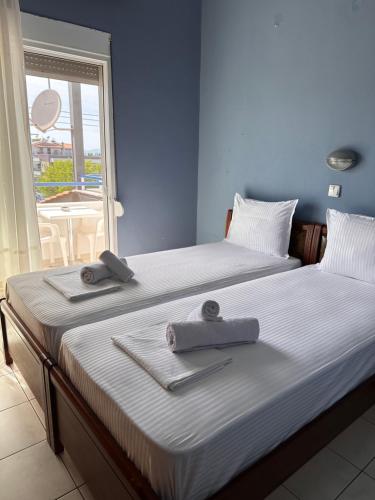 twee bedden in een kamer met handdoeken erop bij Artemis Hotel Apartments in Keramotí