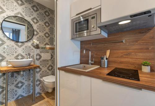 a small kitchen with a sink and a microwave at Agences des Résidences - Rue Commandant André in Cannes