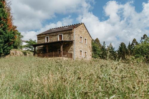 an old brick house in a field of tall grass at Casa Berbesa in Castropol