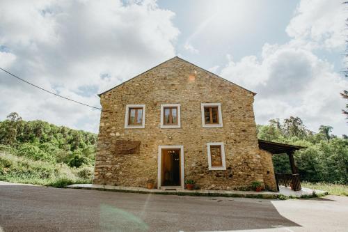 a stone house in the middle of a road at Casa Berbesa in Castropol