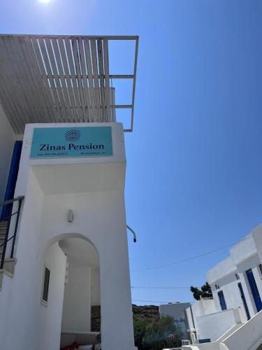 een wit gebouw met een bord dat zames passie leest bij Zinas pension in Ios Chora