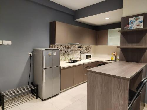 eine Küche mit einem Kühlschrank und Schränken aus Edelstahl in der Unterkunft Regalia Suites KL Infinity Pool _ by MygeHomes in Kuala Lumpur