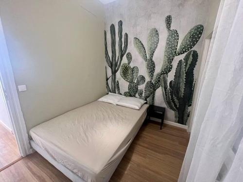 une petite chambre avec une fresque de cactus sur le mur dans l'établissement Saint-Roch station, à Montpellier