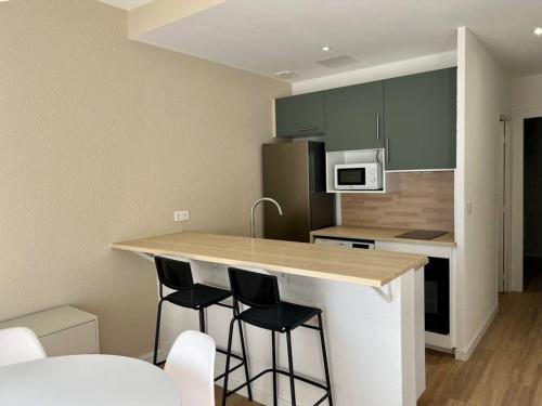 une cuisine avec un comptoir avec quatre tabourets de bar dans l'établissement Saint-Roch station, à Montpellier