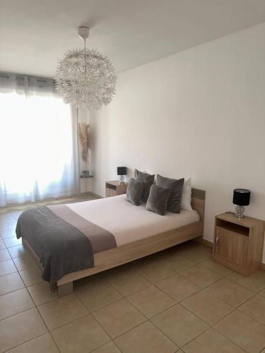 a bedroom with a large bed and a chandelier at Superbe appartement tout équipé avec parking. in Marseille