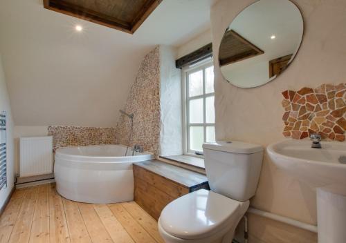 a bathroom with a tub and a toilet and a sink at Shicley in Trevine