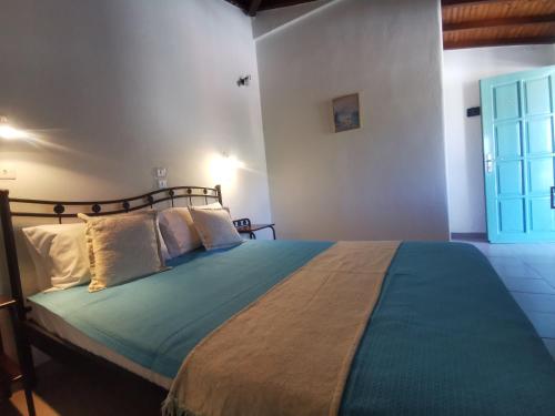 a bedroom with a large bed with a blue blanket at Pension Anna in Patitiri