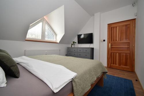 a bedroom with a bed and a tv and a window at Black Hill Apartments in Lauterwasser
