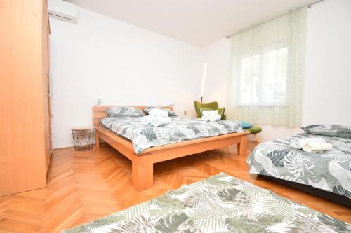 sala de estar con 2 camas y suelo de madera en Helena House Bibinje, en Bibinje