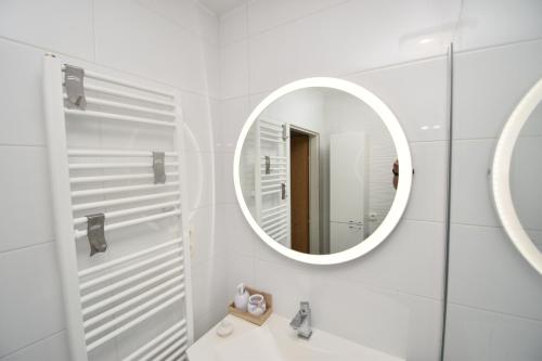 Baño blanco con espejo y lavabo en Helena House Bibinje, en Bibinje