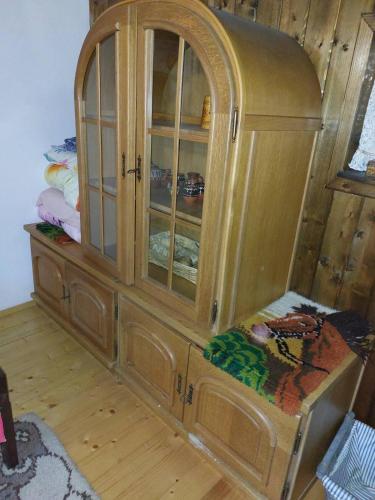 a wooden cabinet with glass doors in a room at Къща за гости КИМ in Apriltsi