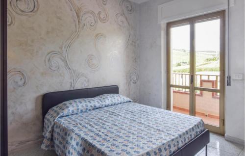Marina di StrongoliにあるNice Apartment In Marina Di Strongoli With 2 Bedrooms And Wifiのベッドルーム(ベッド1台付)、バルコニーが備わります。