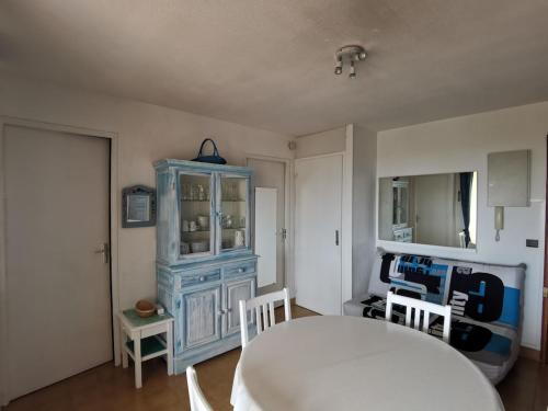 Cette chambre comprend une armoire bleue, une table et des chaises. dans l'établissement Deux pièces avec vue mer, à Fréjus