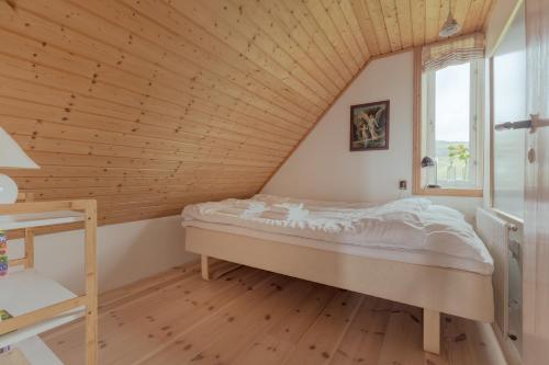 a bed in a room with a wooden ceiling at Stunning Sea View - 3BR - Beach - Scenic Village in Leynar
