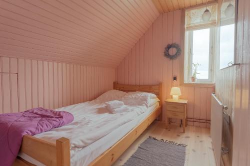 a small bedroom with a bed and a window at Stunning Sea View - 3BR - Beach - Scenic Village in Leynar