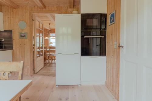 a white refrigerator in a kitchen with wooden walls at Stunning Sea View - 3BR - Beach - Scenic Village in Leynar