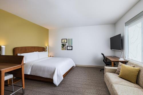 アービングにあるElement Dallas Las Colinasのベッドとソファ付きのホテルルーム
