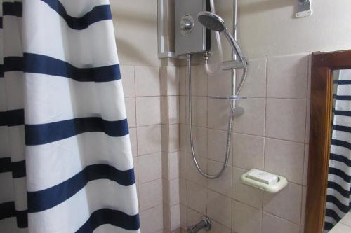eine Dusche im Bad mit Duschvorhang in der Unterkunft Nelsons Retreat in Negril