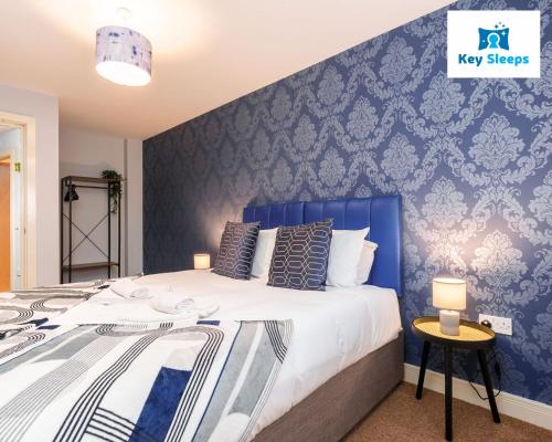 een slaapkamer met een groot bed met een blauwe muur bij One Bedroom Apartment At Keysleeps Short Lets Central Location Leisure Contractor Free Parking in Hull