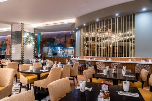 a restaurant with tables and chairs and a bar at The Cumberland, London in London