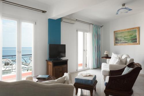 Tinos Resort في تينوس تاون: غرفة معيشة مطلة على المحيط