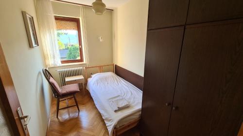 Habitación pequeña con cama y ventana en Apartment Ajdna, en Žirovnica
