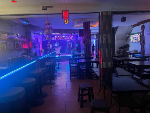 a bar with tables and stools and purple lights at อีสานจอมเทียน in Jomtien Beach