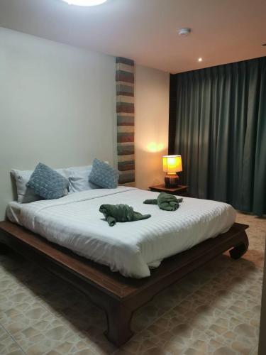 a bedroom with a bed with two stuffed animals on it at อีสานจอมเทียน in Jomtien Beach