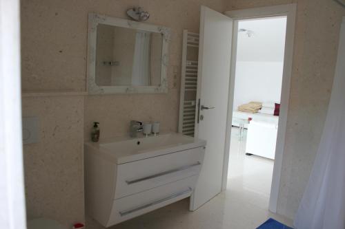 a bathroom with a white sink and a mirror at Vila Vito in Trogir