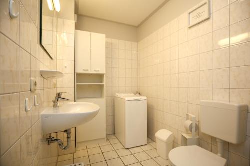 a white bathroom with a toilet and a sink at Urlauberdorf Haus 21b in Boltenhagen
