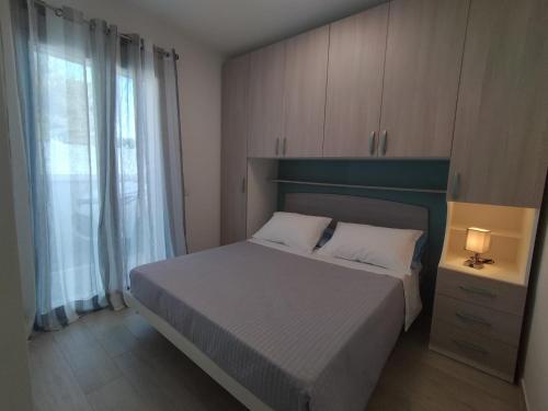 ein kleines Schlafzimmer mit einem Bett und einem Fenster in der Unterkunft APARTMENT VELA SUITE in Alba Adriatica