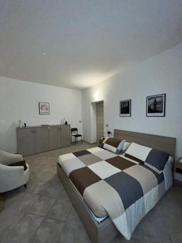 - une grande chambre avec un grand lit et une chaise dans l'établissement Casa Valeria, à Tuscania